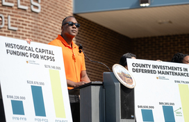 County Executive Calvin Ball speaking at a podium outside Oakland Mills Middle School during his press conference where he announced he will fully fund Howard County Public School System and its Board of Education’s Fiscal Year 2027 Capital Budget. 