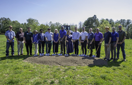 County Executive Calvin Ball with Department of Recreation & Parks employees and other community members posing with shovels in hand and a mound of dirt in front of them outside before digging into the ground to ceremoniously break ground on Cradlerock Park in Columbia.