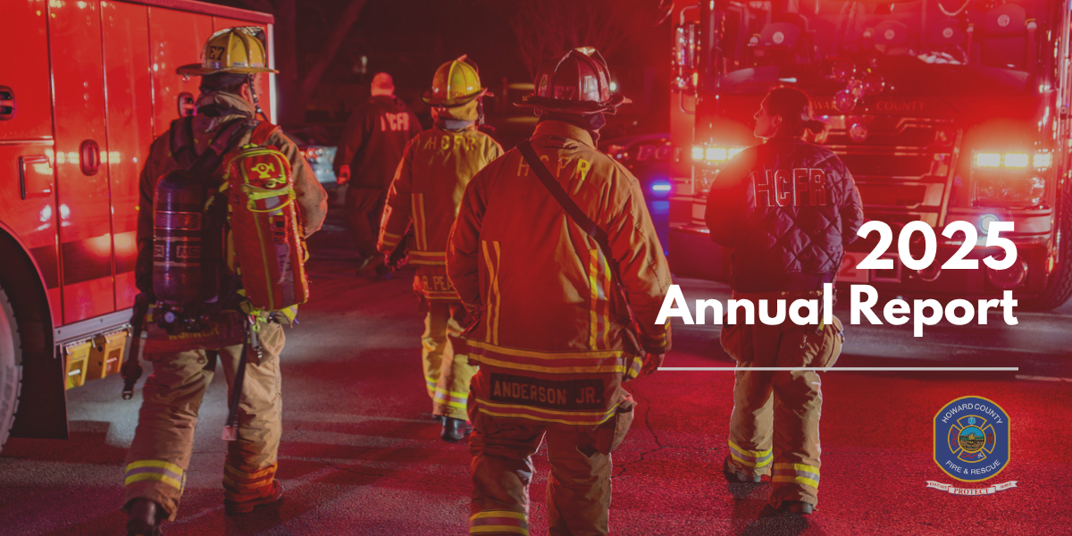 Firefighters walking at night in front of a fire engine