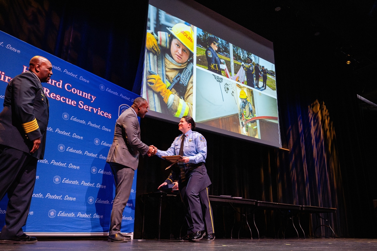 Recipient shakes County Executive's hand on stage