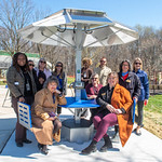 Group of Howard County Staff posing, smiling around a blue and silver solar table.