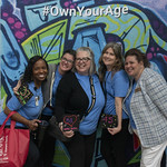 Office on Aging staff pose in front of the "Own Your Age" Photobooth.
