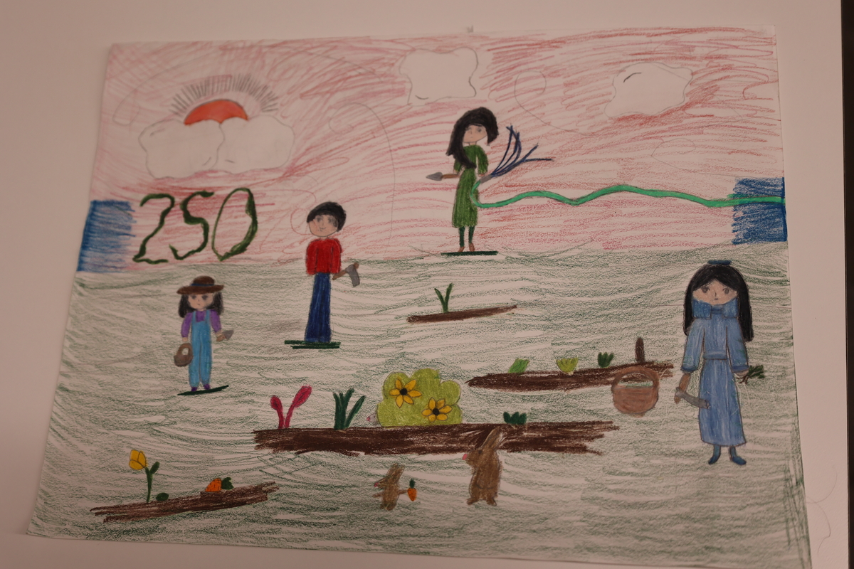 Child's drawing is of a family gardening together.