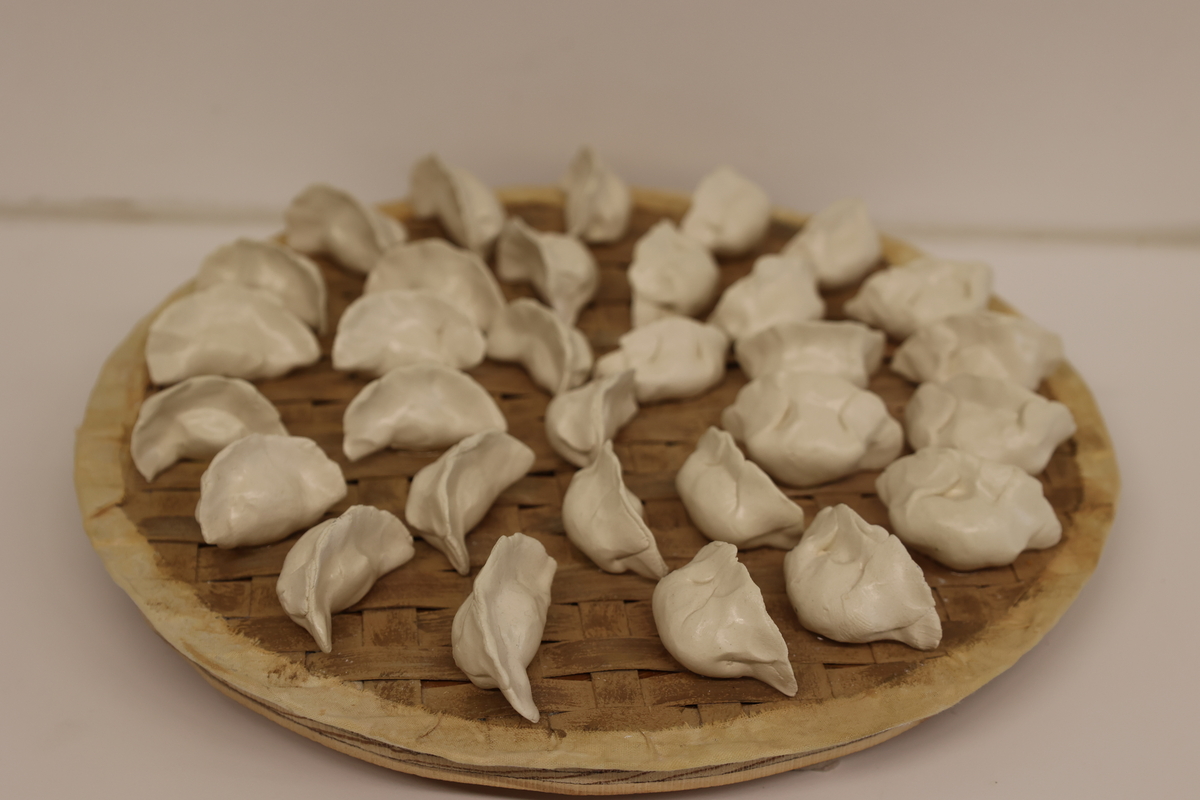 This is a 3D artwork of dumplings on a plate.