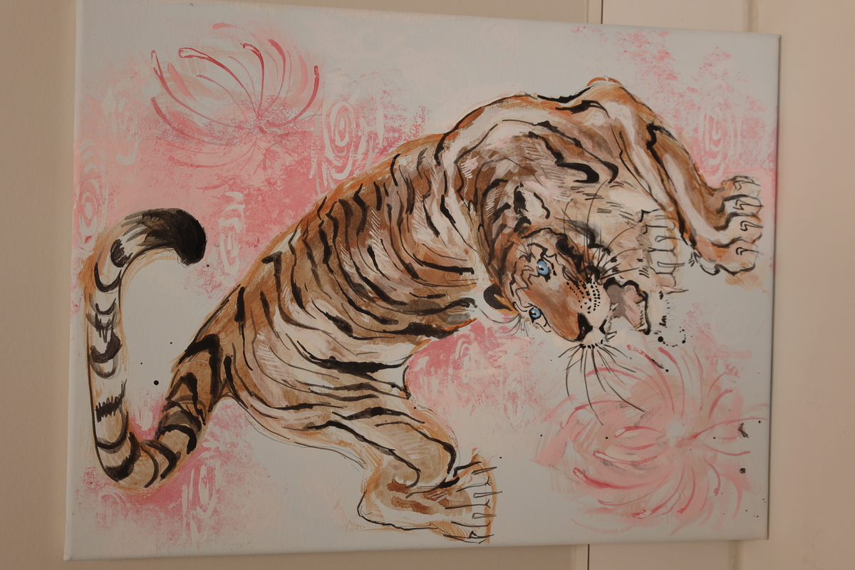 This is a drawing of a tiger and a pink lotus flower on the side and in the corner.