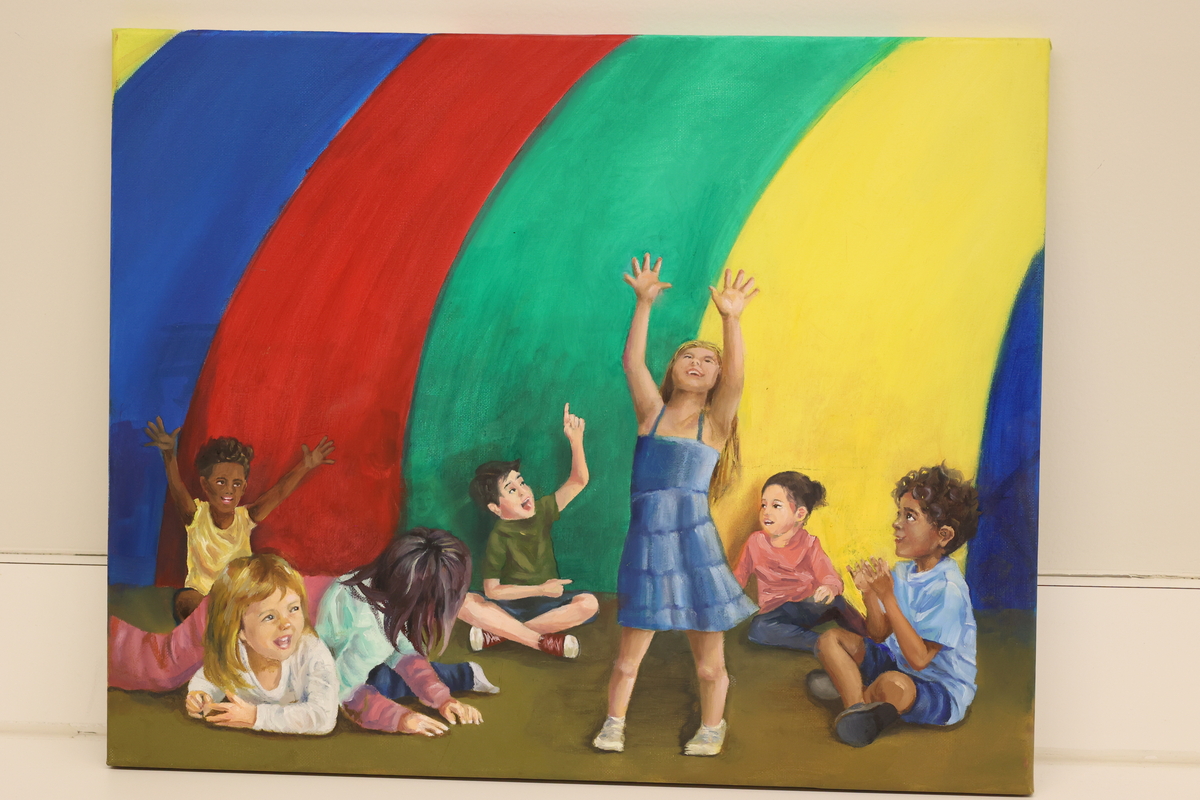 This drawing is of different children playing under a rainbow parachute.