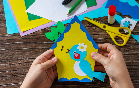 creating a birdhouse craft with construction paper