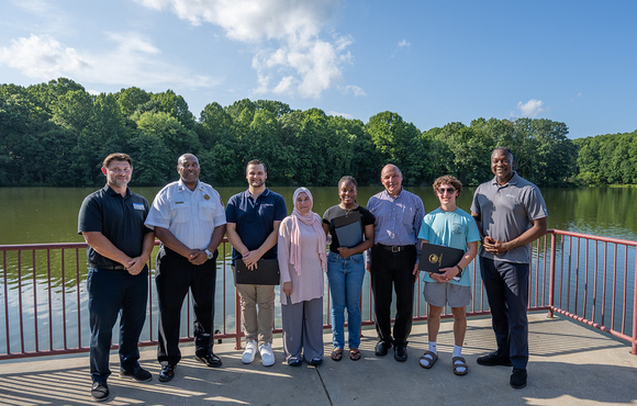 A photo of County Executive Calvin Ball and others with the three heroes that rescue a woman from drowning at Centennial Lake.