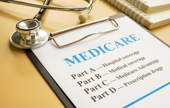 Stethoscope and clipboard with paper that says Medicare: part A, part B, part C, part D