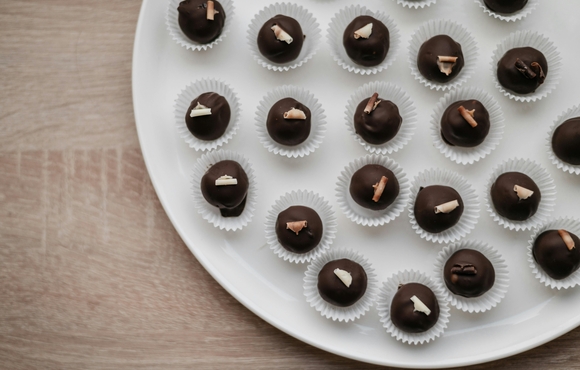 Tray filled with chocolate truffles in paper baking cups.