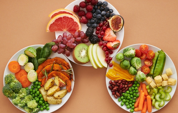 Three plates willed with a colorful mix of fruit and vegetables.