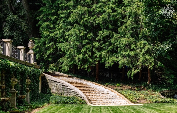 Stone staircase at Longwood Gardens with pine trees in the background.