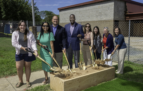 County Executive Calvin Ball posed for a photo with other elect officials, community members, and Howard County Public School System officials, in front of a large rectangular box of dirt and all holding shovels ready to break ground on the new Faulkner Ridge Early Learning Center at the former Faulkner Ridge Center in Columbia.