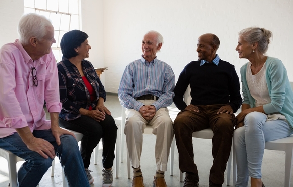 A group of people sitting together and having a conversation.