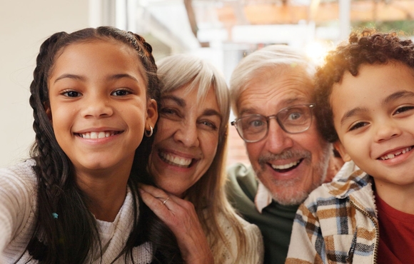 grandparents and grandchildren pose together for a photo. 