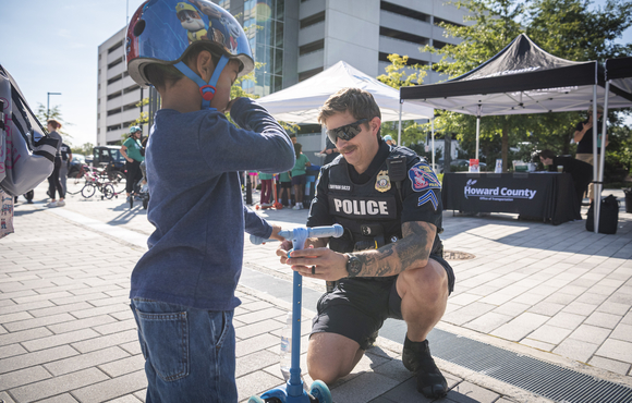 Officer helps a young child with a scooter