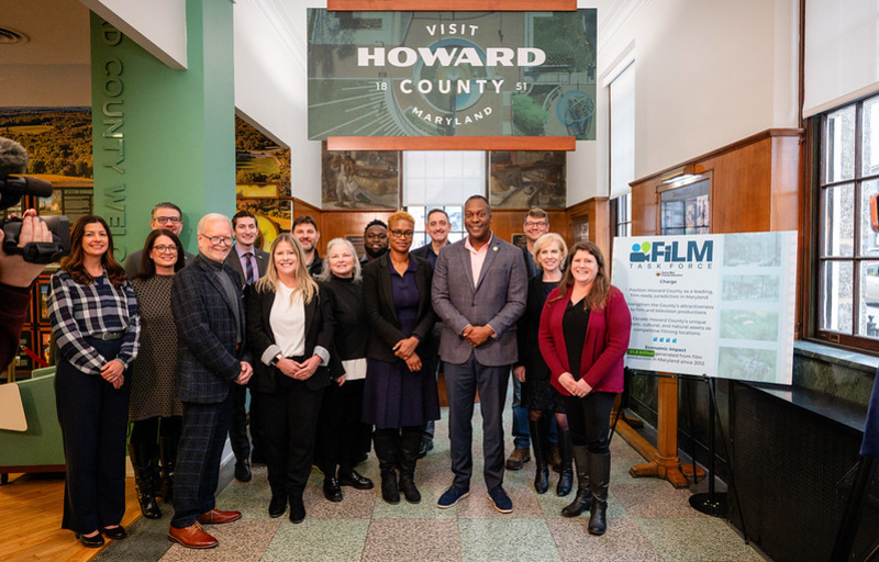 A photo of County Executive posed with members of his new Film Industry and Location Marketing (FILM) Task Force in side the Visit Howard County welcome center.