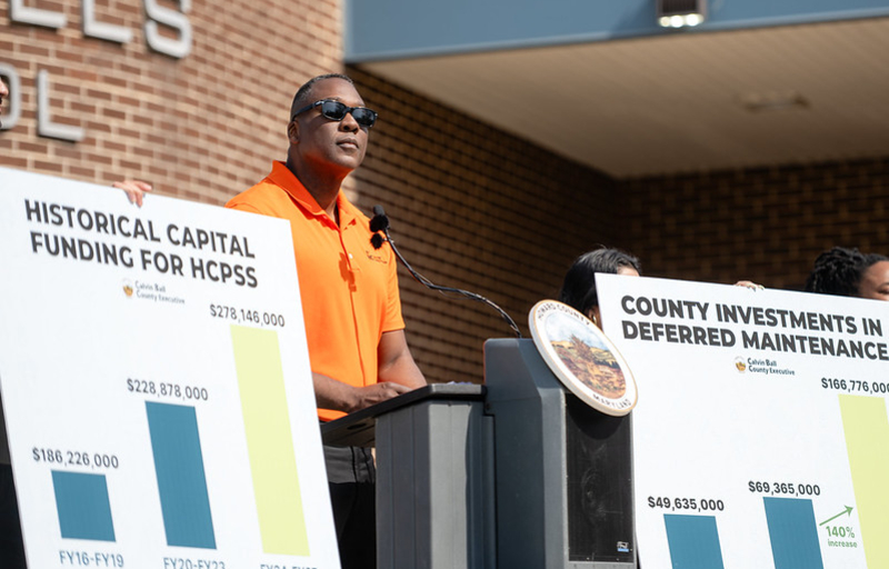 County Executive Calvin Ball speaking at a podium outside Oakland Mills Middle School during his press conference where he announced he will fully fund Howard County Public School System and its Board of Education’s Fiscal Year 2027 Capital Budget. 