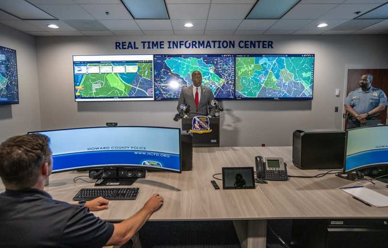 County Executive Calvin Ball standing at a podium inside the Howard County Police Department's new Real Time Information Center for his press conference about the center and this new innovation technology helping officers police better.