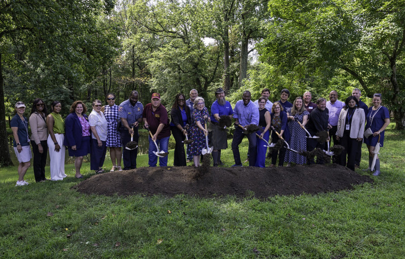 County Executive Calvin Ball posed with other Howard County Government employees and Elkridge community members holding up shovels after just digging into a dirt mound to mark the groundbreaking of the new Elkridge Community and 50+ Center on August 3, 2026.