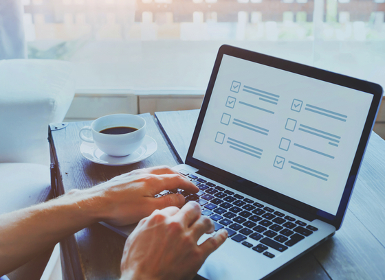 Laptop open with survey on screen and person's hands typing