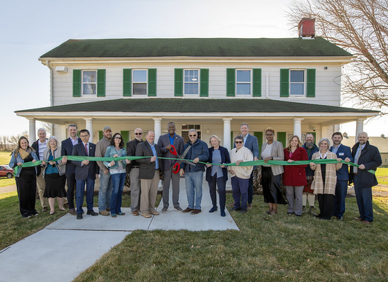 Group of participants cutting a ribbon in front of new office of agriculture.