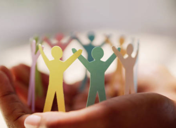 hands holding paper cut-out people holding hands (decorative)