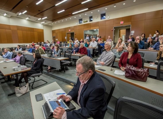 A public Land Development Regulation Assessment being conducted by Clarion Associates. The photo focuses on a male taking notes on a tablet.