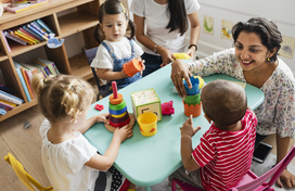 teacher helping four children