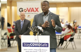 Calvin Ball speaking at mall in columbia mass vax site, governor in background