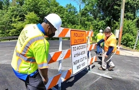 Image of Calvin Ball removing a road closed sign