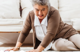Older Asian woman on the floor with a cane after she fell.