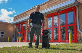 A photo of Department of Fire and Rescue Services Captain Craig Matthews and the department's new arson dog Beacon out front of Station 12.