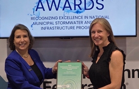 A photo of Office of Community Sustainability Stormwater Programs Manager Lindsay DeMarzo receiving WEF's MSF Phase I Innovation award at its annual conference in Chicago. 