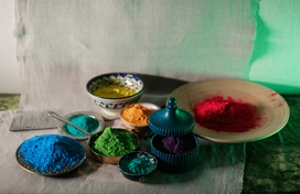 7 bowls filled with a variety of different powdered colors.