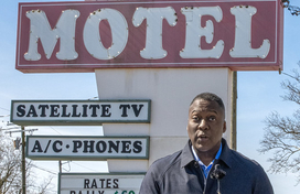 County Executive Calvin Ball standing at a podium in front of the Terrace Motel sign on US 1 speaking to press conference attendees about his support of Zoning Regulation Amendment 221.