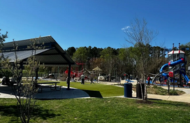 photo of a playground with a picnic pavilion in the foreground
