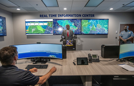 County Executive Calvin Ball standing at a podium inside the Howard County Police Department's new Real Time Information Center for his press conference about the center and this new innovation technology helping officers police better.