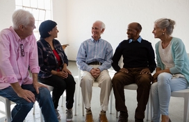 A group of people sitting together and having a conversation.