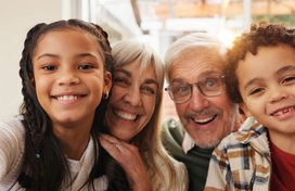 grandparents and grandchildren pose together for a photo. 