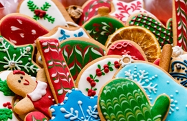 an assortment of holiday cookies in reds and greens and blues and whites shaped like gingerbread people, snowflakes, mittens, and candy canes