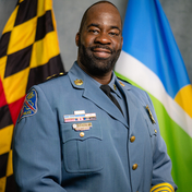 Terrence Benn pictured in front of the Maryland State and Howard County flags. 