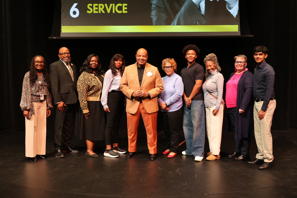 An image of 10 people in business casual dress stood on a stage. 