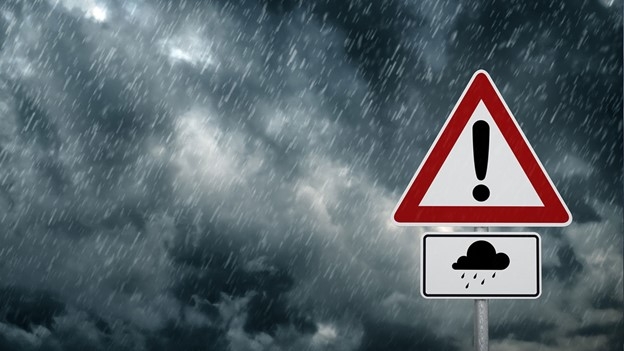 Warning road sign for hazardous conditions in heavy rain and stormy weather.