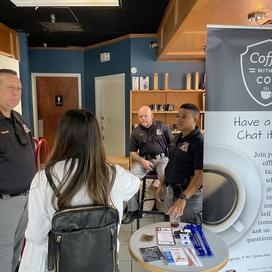 Officers talk to a citizen at Coffee with a Cop