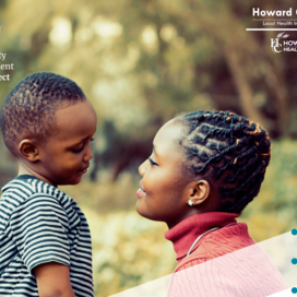 Black woman smiling at young black boy outdoors.