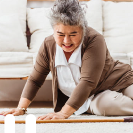 Older Asian woman on the floor with a cane after she fell.