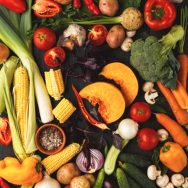 Assorted fresh fruits and vegetables on a black background