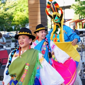 Three dancers in colorful dresses at the 2024 Hispanic Heritage Festival 