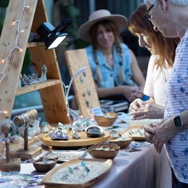 Older adults shopping at a craft fair table.